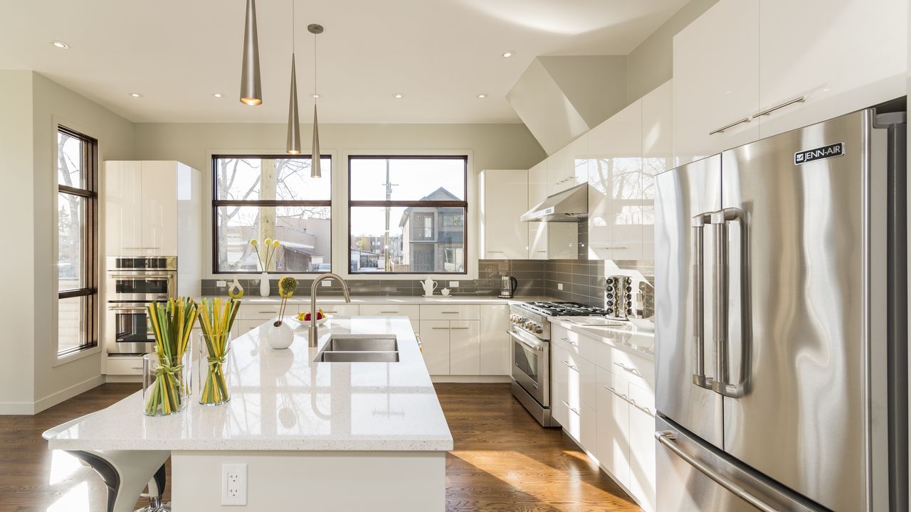 Modern Queens kitchen with stainless steel refrigerator and gas range